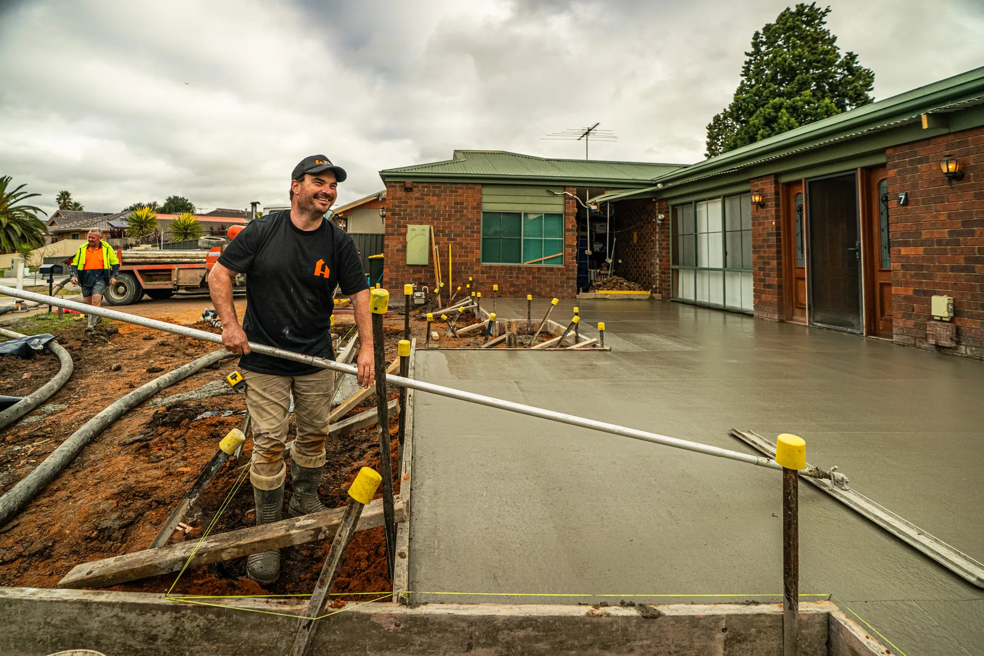 Tradie screeding a fresh concrete slab