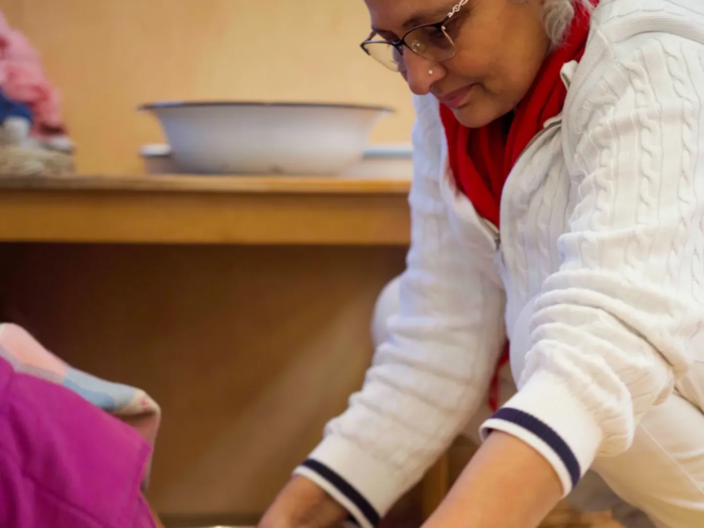 An educator helping a child wash their hands