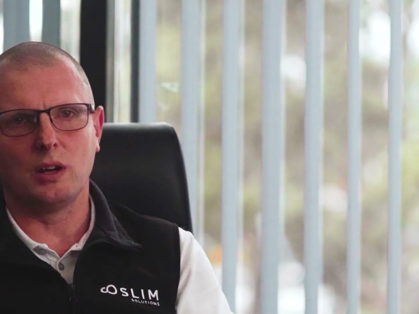 A business owner speaking on camera in his office