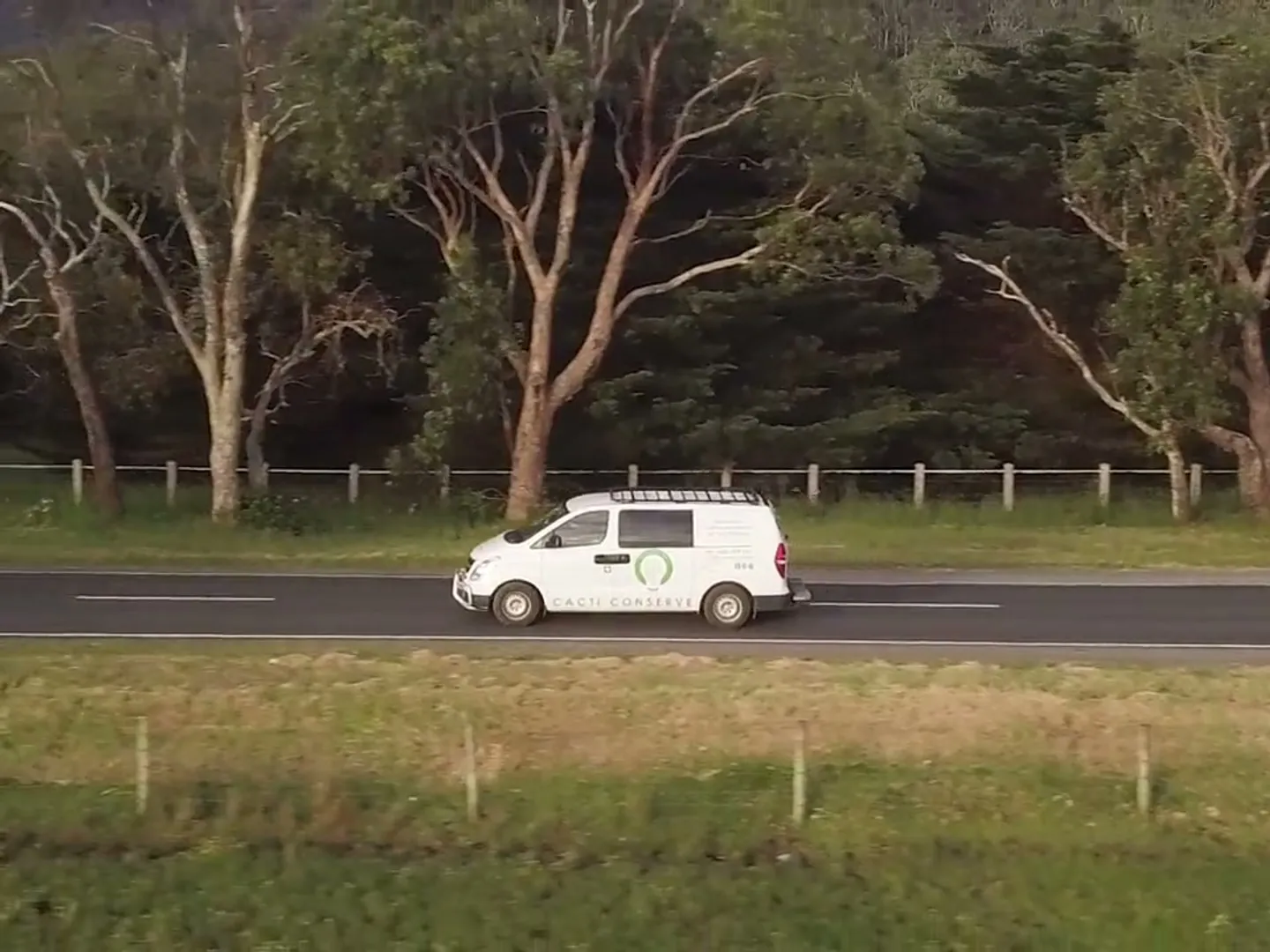 Drone shot following a van along a road beside the ranges