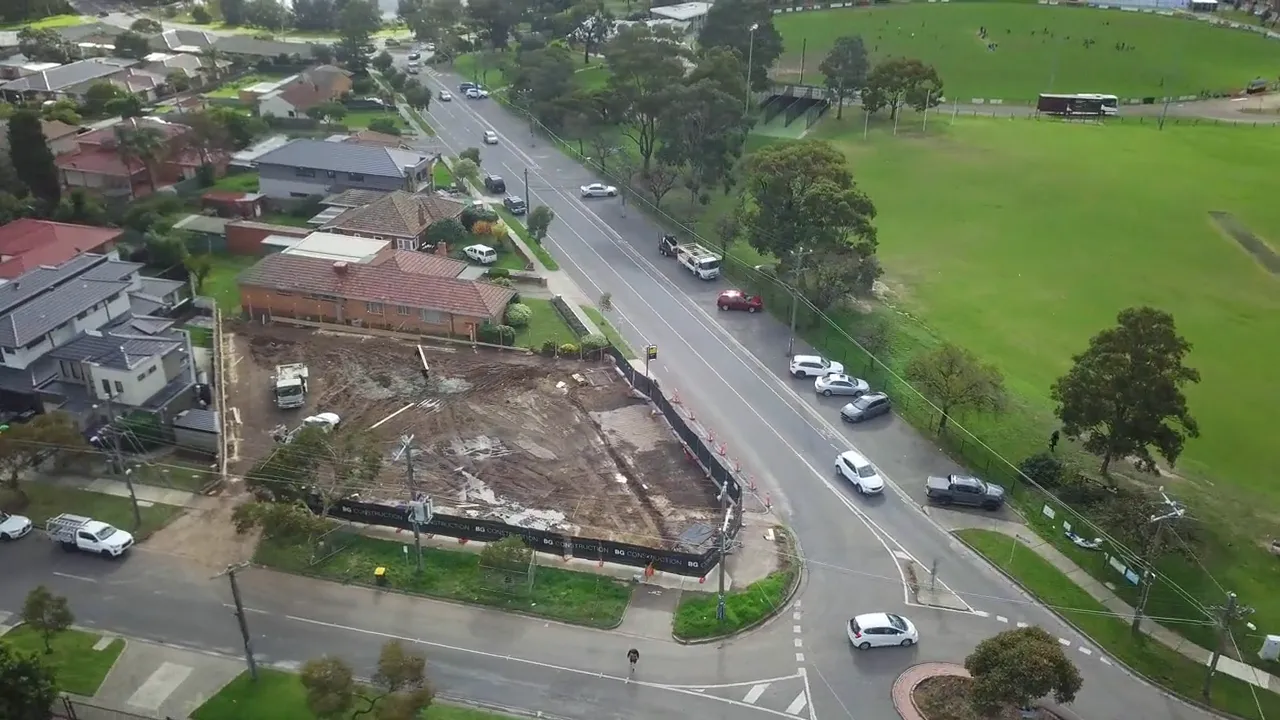 Drone view along the street beside the site and the oval