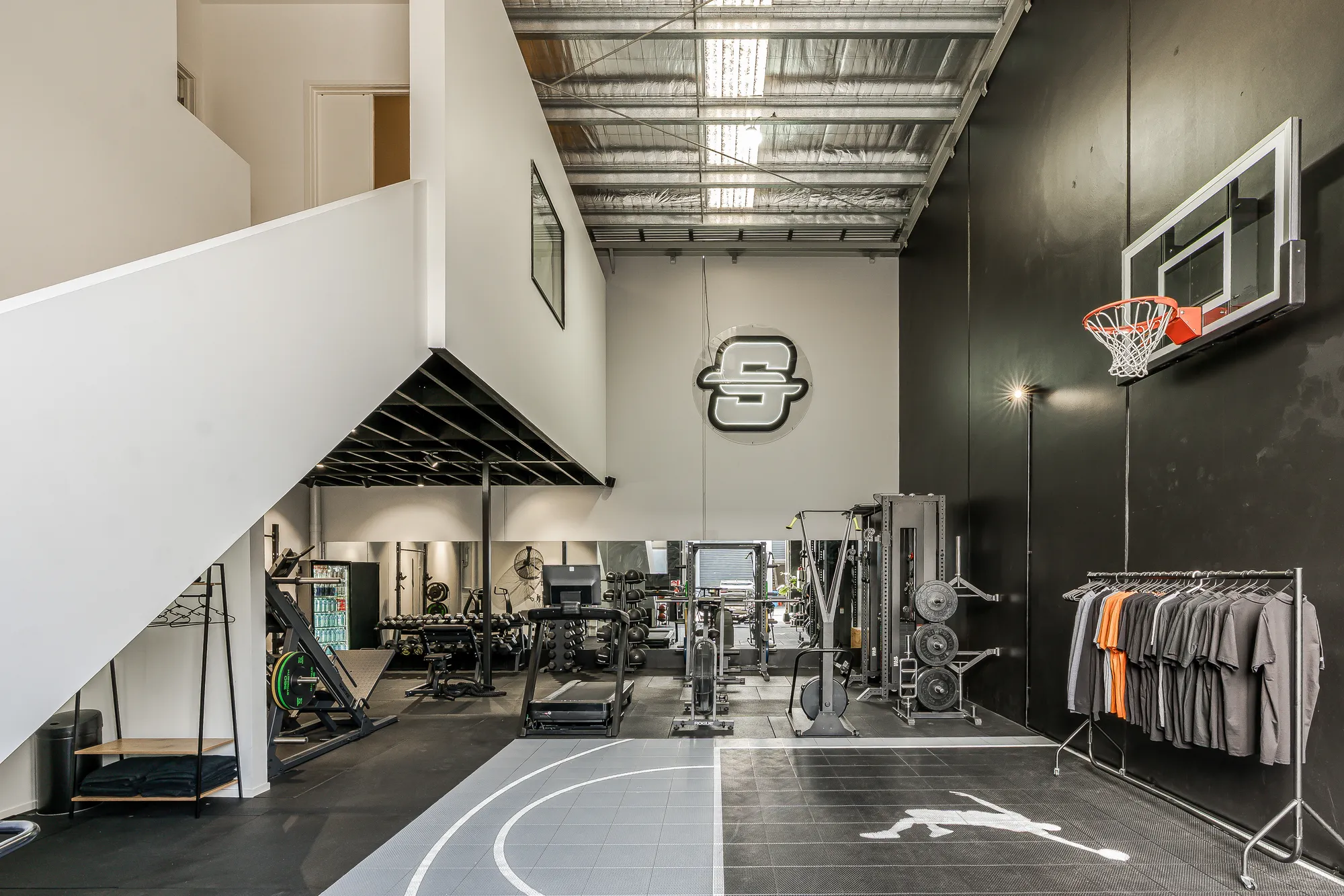 The Pinnacle HQ training floor with a basketball hoop and logo wall