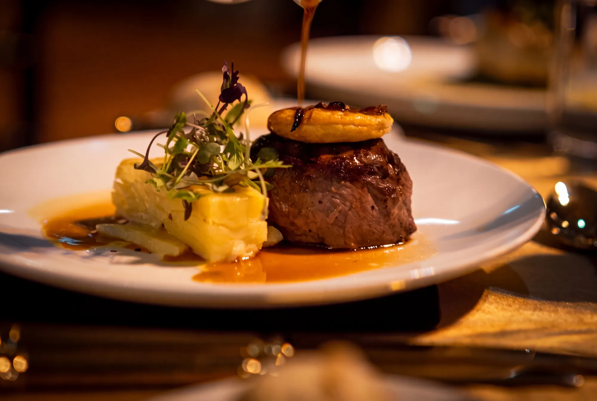 Eye fillet main course with sauce being poured